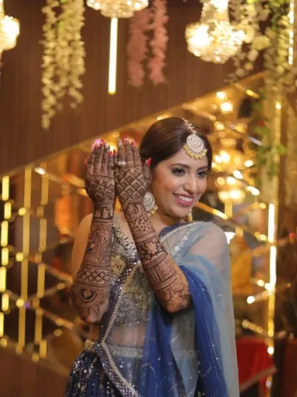 A beautiful shot of a model with her mehndi, wearing my blue lehenga.