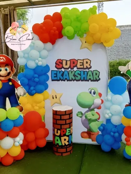 Bringing the game to life with a Super Mario themed birthday party. This outdoor setup includes character cutouts of Mario and Luigi, a custom backdrop, and vibrant balloon columns.