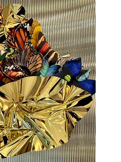 The texture of the golden steel contrasts with the smooth, printed surfaces of the polycarbonate wings.