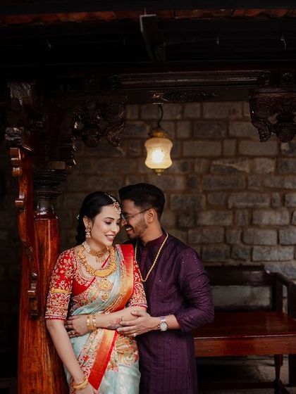 A couple shares an intimate moment under a traditional wooden awning, framed by the venue's architecture.