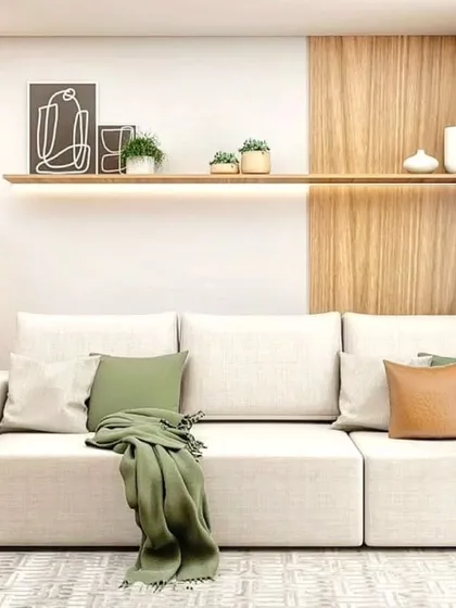 A minimalist living room with a white sofa and a simple floating shelf. The design emphasizes clean lines and a clutter-free environment.