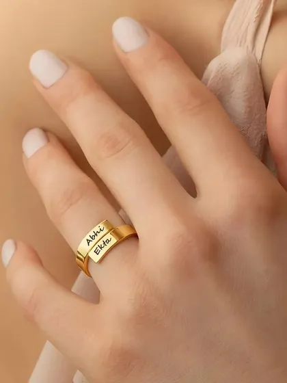 Our exclusive couple name ring, elegantly worn. This adjustable design allows for two names to be engraved on the overlapping bands, symbolizing your connection.
