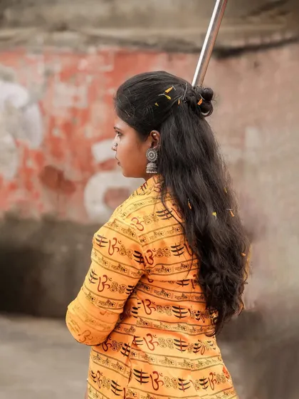 A profile shot of a female troupe member, her hair tied back, ready for the performance.