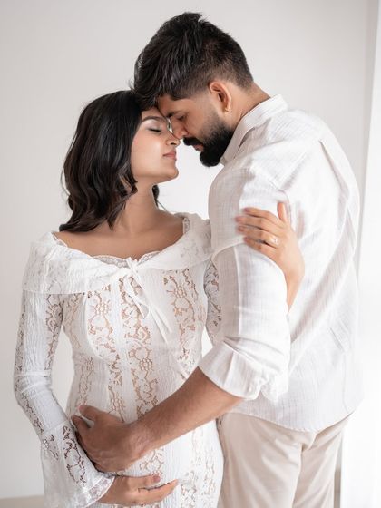 An intimate and romantic pose from a couple's maternity session, with their foreheads touching.