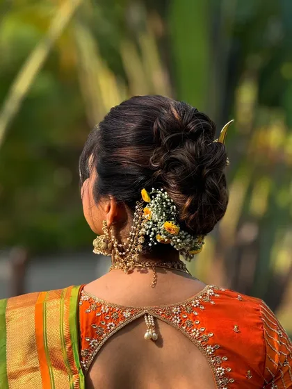 A close-up of the textured bridal bun, showing the interwoven sections and the careful placement of flowers and accessories for a flawless finish.