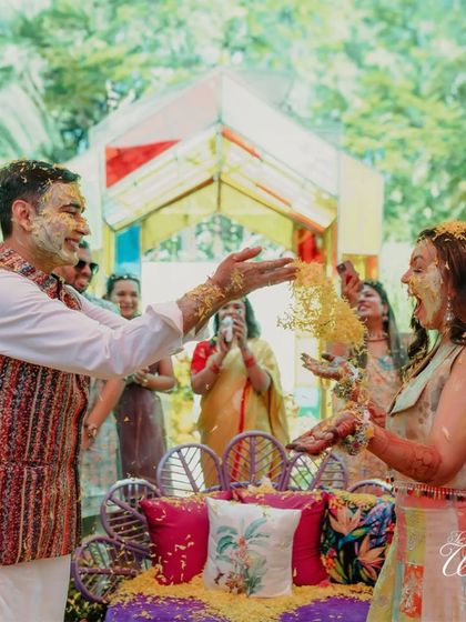 A shower of flowers and laughter. This candid shot captures the playful spirit of the Haldi ceremony, a moment of pure celebration and love.