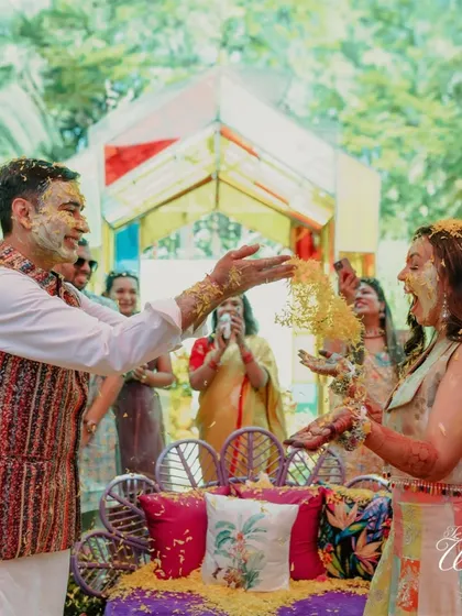 The playful side of a Haldi ceremony. The groom showers the bride with flower petals, and her joyful reaction is what makes these events so memorable.