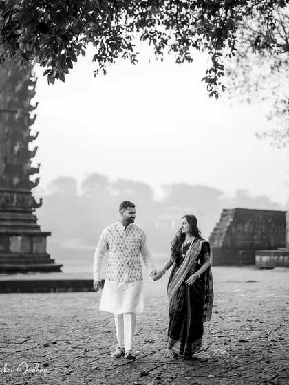 A quiet walk through a historic landscape. This black and white frame of Ankush and Aishwarya captures a timeless, romantic feeling, focusing on their connection as they stroll hand-in-hand.
