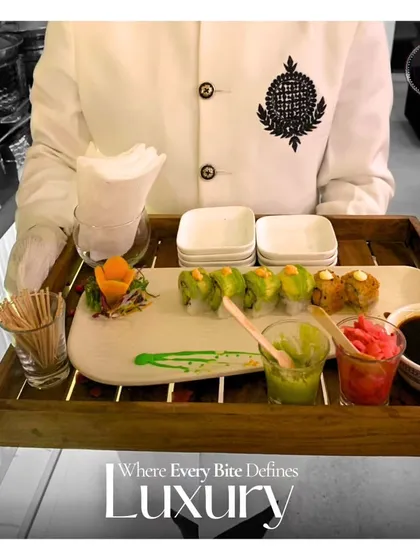 Where every bite defines luxury. A server presents a tray of beautifully plated sushi, emphasizing our focus on creating a high-end dining experience through both taste and presentation.