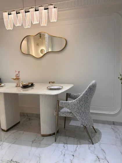 A different angle of the dining area, focusing on the unique texture of the dining chair and the clean lines of the table. The design is minimalist yet full of interesting details that invite a closer look.