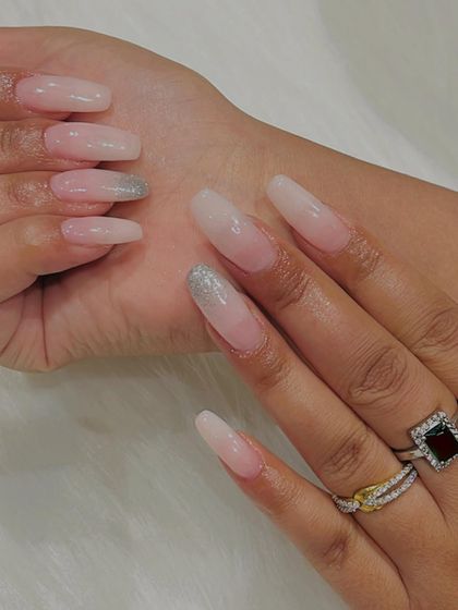 A full view of these long, coffin-shaped ombré nails with a silver glitter accent. This style is perfect for adding glamour and length.