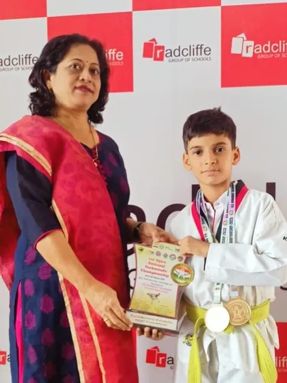 A champion receiving her certificate and medal from the school principal. We build skills that are recognized everywhere.
