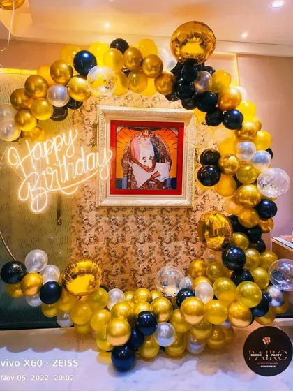 A black and gold balloon ring setup designed to frame a cherished family photo, adding a personal touch to the celebration.
