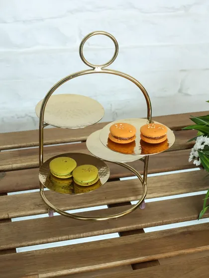 The modern Tête-à-tête stand with three hammered gold plates. Its unique, asymmetrical design is perfect for adding a contemporary touch to your afternoon tea service.