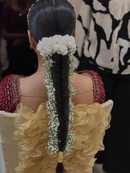 A neat fishtail braid becomes instantly ethereal with the addition of baby's breath woven throughout. This is a wonderful option for a Mehendi or Haldi ceremony, offering a look that is both practical and enchanting.