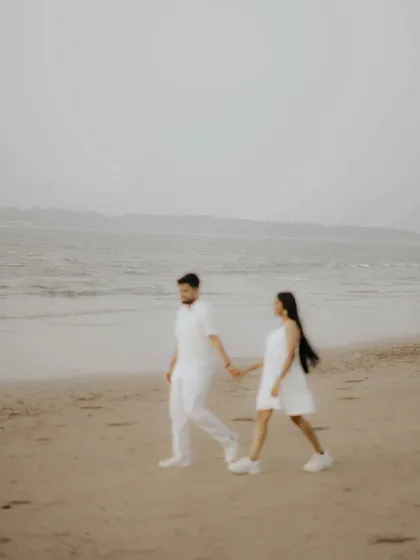 A soft-focus shot of a couple walking along the beach. This artistic photo creates a dreamy, romantic mood for a pre-wedding memory.