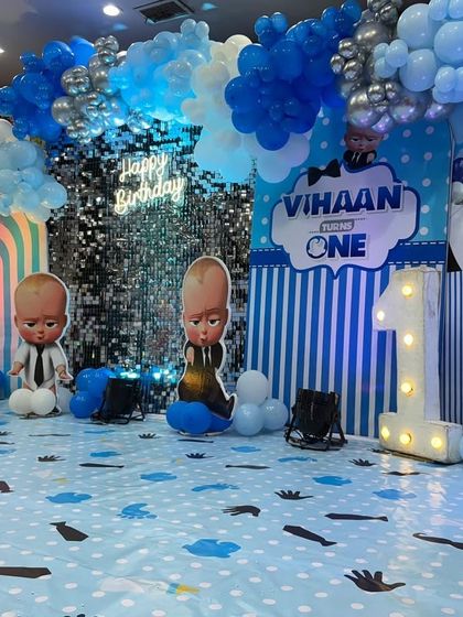 The main photo area for the Boss Baby party, featuring a shimmer wall, a rainbow arch, and several Boss Baby cutouts for fun photo opportunities.