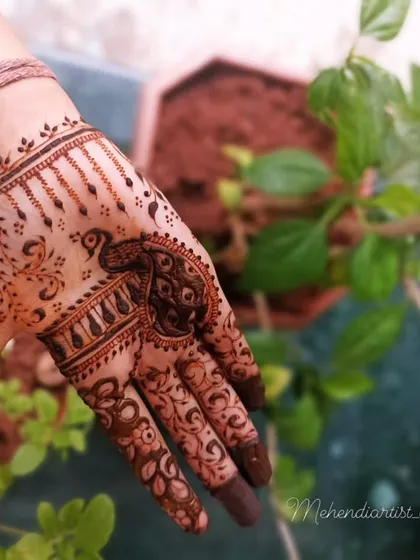 A lovely peacock motif done in an Arabic style. The design is focused on the palm and fingers, leaving the wrist open for a lighter feel.