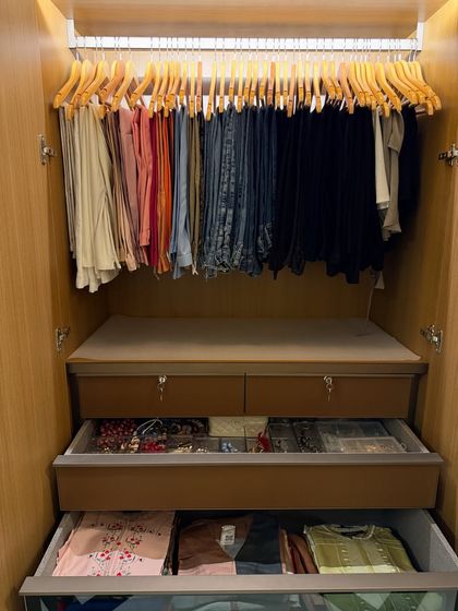 This view shows how we integrate hanging space for trousers with pull-out drawers for accessories and folded items, ensuring every inch of the closet is functional.