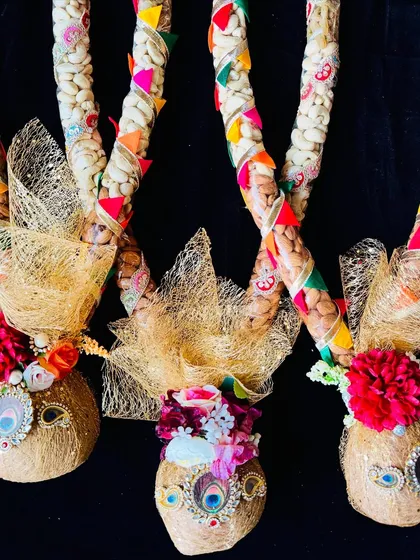 A festive garland made with coconuts and dry fruits, wrapped in golden net for a luxurious gifting experience.
