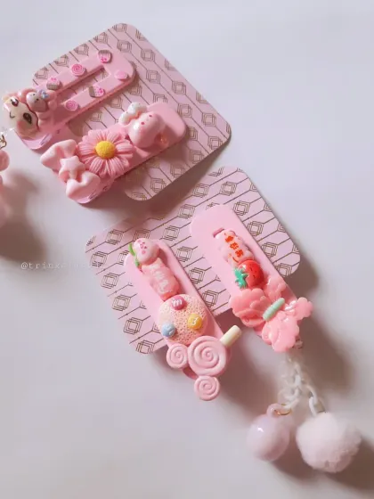 A closer look at some of my pink hair clip designs. This set includes dangling pom-poms and a mix of cute charms, all ready to be packed as a special gift or party favor.