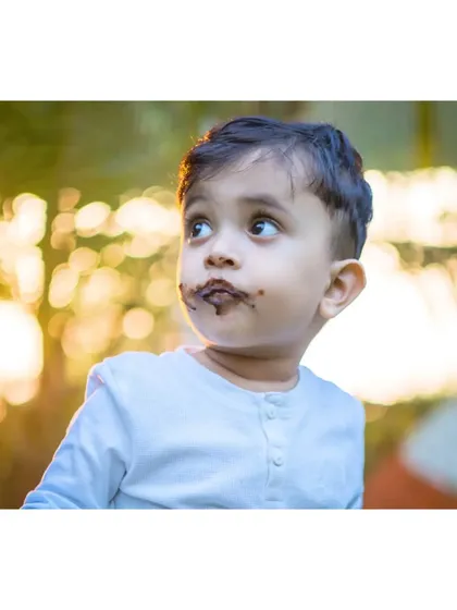 A thoughtful look away from the camera, with chocolate still on his face. Even in the middle of a fun cake smash, I look for these quiet, candid moments that reveal a child's personality.