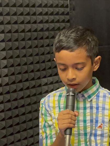 A young vocalist focused at the microphone during a jam session. We create a professional yet encouraging atmosphere for students to experience live performance.
