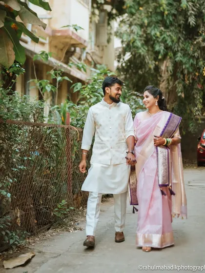 A candid shot of the couple taking a stroll down a quiet, leafy lane. This natural, unposed moment captures the easy comfort and companionship they share.