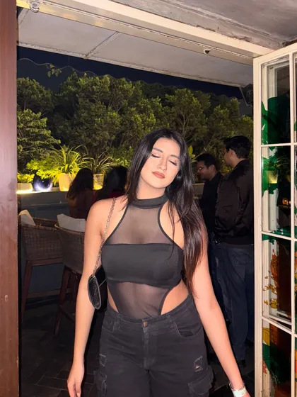 "Sweet but spicy." A black mesh bodysuit paired with black cargo pants for a girls' night out.