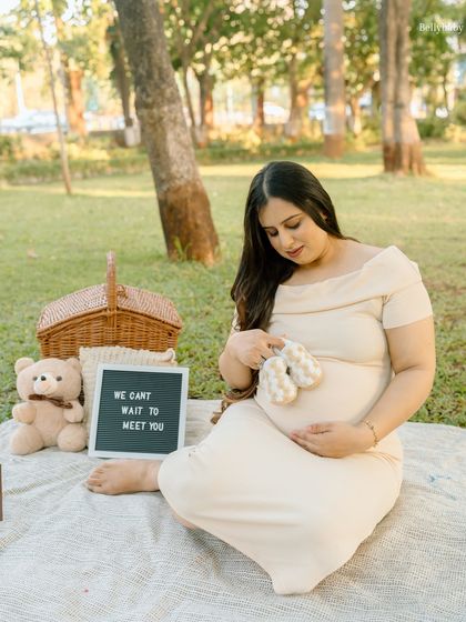 "We can't wait to meet you." Holding up the tiny baby shoes is a classic and heartwarming way to show all the love and preparation for the new arrival.