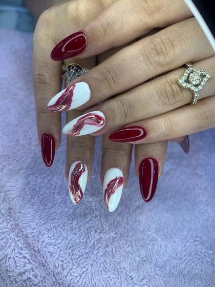 A gorgeous red and white marble effect on almond-shaped nails. This design is both elegant and artistic.