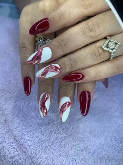A beautiful red and white marble design on long, almond-shaped nails.
