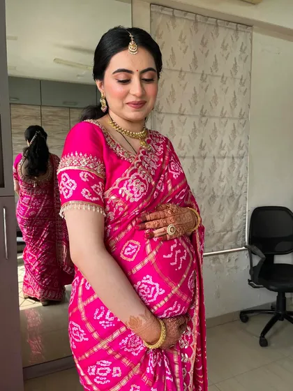 A serene moment. The makeup is kept soft and elegant, ensuring the focus remains on the beautiful mom-to-be.