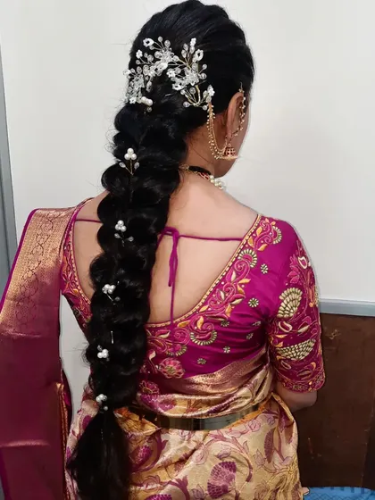 A voluminous braid accessorized with a beautiful silver floral clip. This style is perfect for receptions and parties.