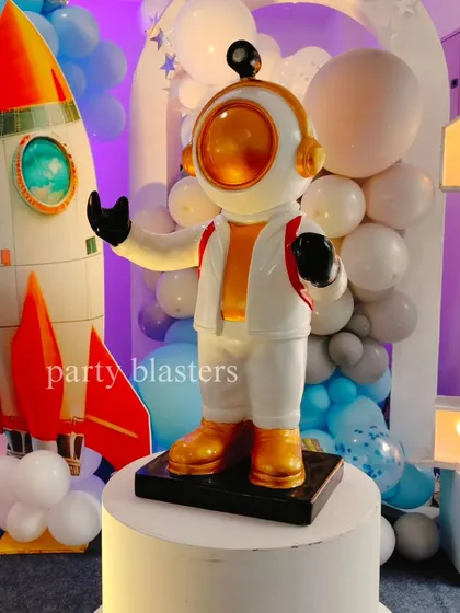 Another angle of the detailed astronaut figure, standing next to a rocket and surrounded by a galaxy of balloons.