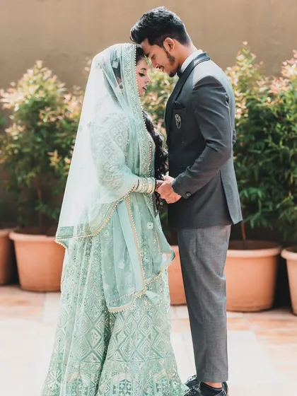 An intimate and serene portrait of a couple on their wedding day, holding hands and sharing a quiet moment together.