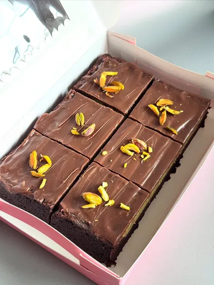 Here's a look inside a box of my special Kunafa Brownie Bars. I layer my best-selling fudgy brownies with a crunchy pistachio kunafa filling and top it all with smooth milk chocolate for a perfect blend of textures.