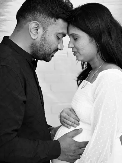 A timeless black and white portrait that focuses on the deep connection between the expecting parents. The soft lighting and intimate pose create a powerful and emotional image, stripping away all distractions.