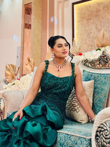 Posing in a beautiful emerald green gown before a reception event. The intricate beadwork and mermaid silhouette make it a real showstopper for an evening of elegance.