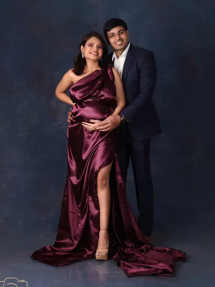 A classic and elegant pose for an expecting couple. The rich satin gown and the sharp suit create a timeless and sophisticated look.
