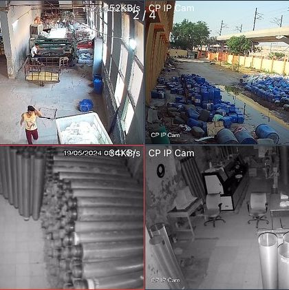 A four-camera view from a surveillance system in a Faridabad industrial unit. The cameras effectively monitor the factory floor, outdoor storage, and a stock room with stacked pipes, showcasing both day and night vision capabilities.