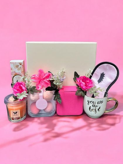 A pretty pink-themed pamper hamper for a sister. This gift set includes a scented candle, a "You are the best" mug, a satin eye mask, and other beauty essentials.
