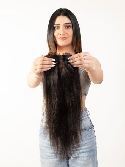 A model holding a long hair topper, showcasing its length and volume.