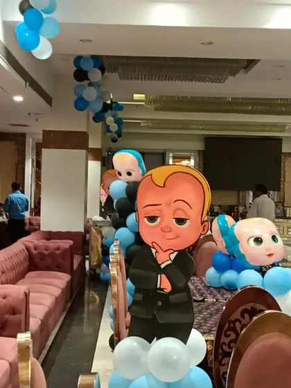Boss Baby character cutouts on balloon bases used as decorative elements throughout the party venue.