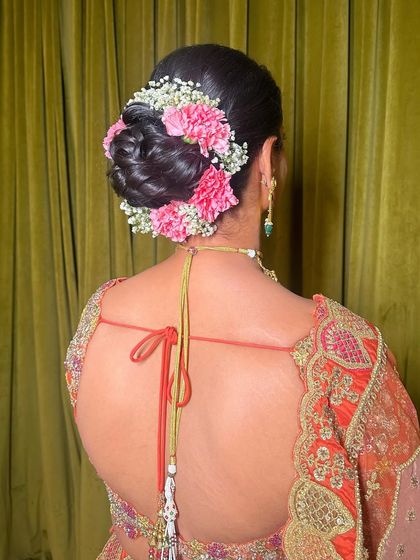 A detailed shot of the beautiful floral bun, which adds a touch of romance and tradition to this bridal look.