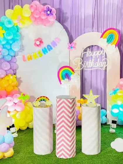 A vibrant and cheerful Rainbow theme birthday party. This setup includes multiple backdrops, colorful balloon arrangements with flower accents, rainbow cutouts, and a balloon number '4' to create a bright and happy celebration.