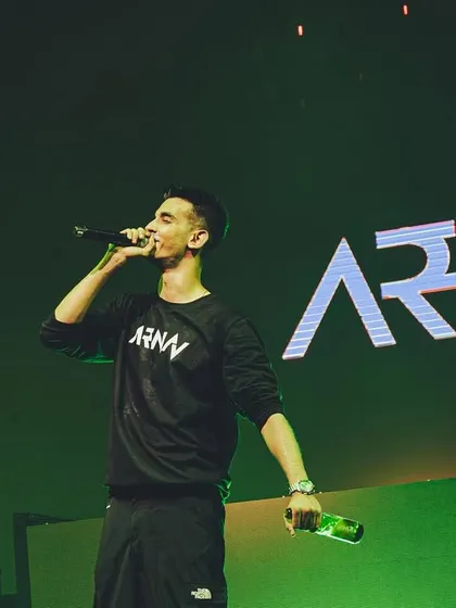 On the mic, commanding the stage during a concert. My performance style involves direct engagement to build energy and connect with everyone in the venue.