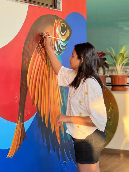 A candid shot of me adding the final touches to the eye of the flying fish. This image captures a moment of intense focus during the creation of a large-scale art piece.