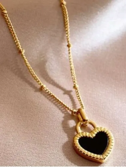 Another look at the heart padlock necklace, showing the detail on the pendant and the delicate satellite chain.