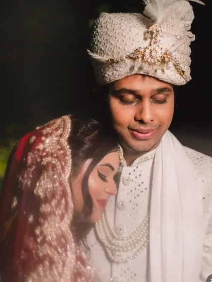 An intimate and romantic close-up of the bride and groom. Her makeup looks stunning even in the soft, dark lighting.